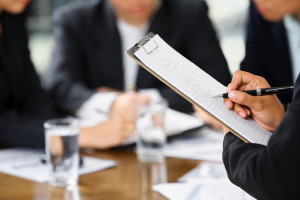 Hand writing with other business people in background